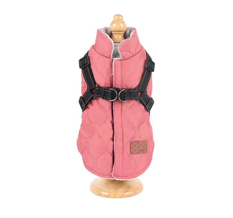 Pink dog coat with black harness on a wooden stand against a white background