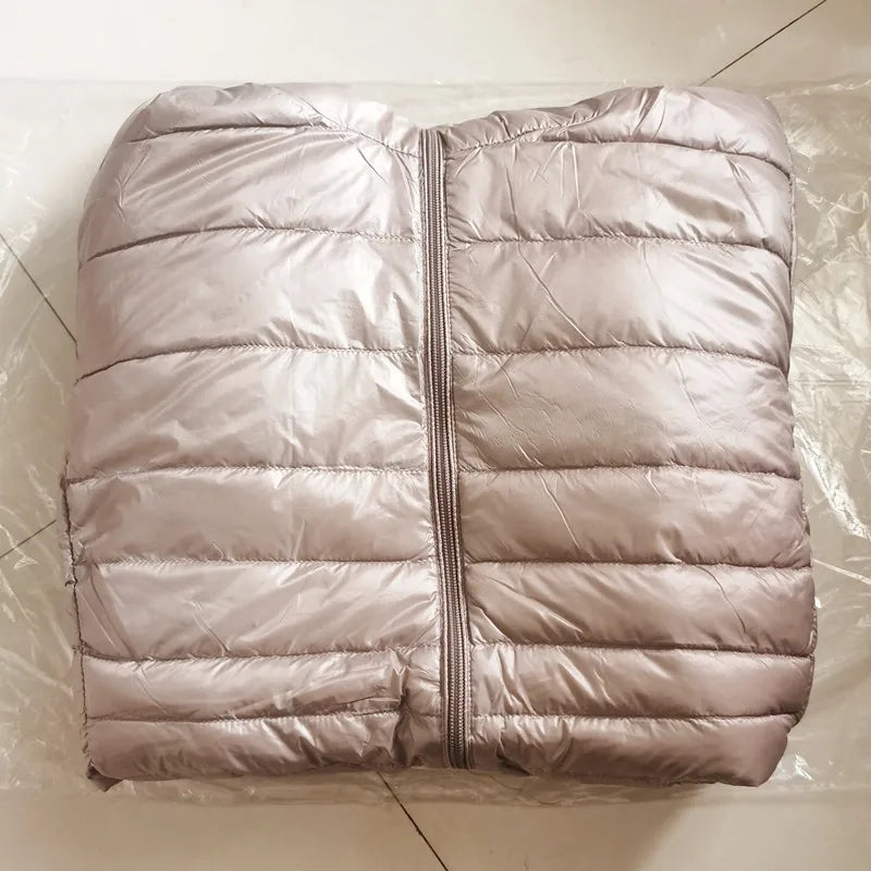Folded beige puffer jacket on a tiled floor