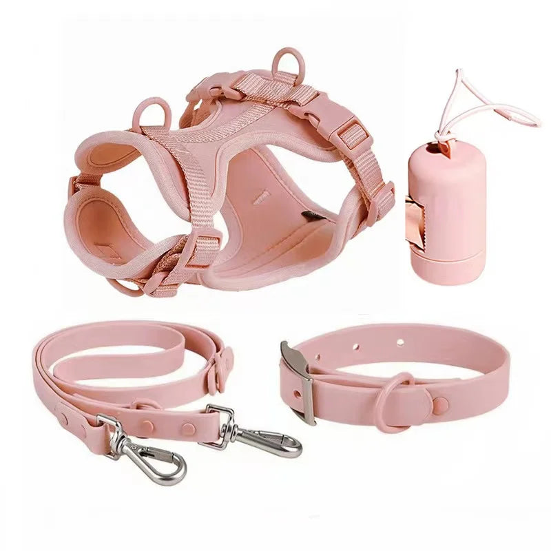 Pink dog harness, leash, collar, and training clicker on a white background