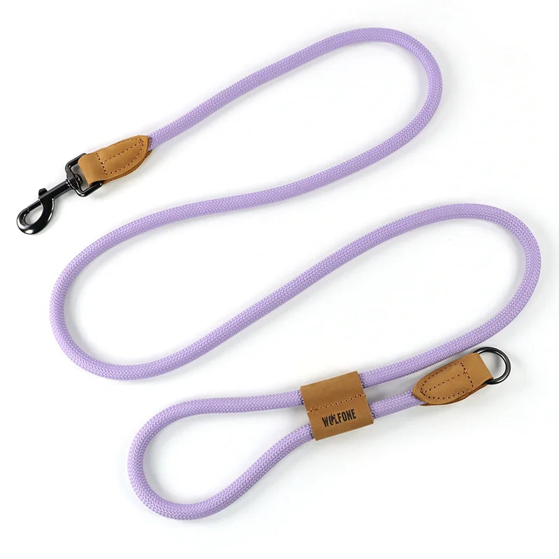 Purple dog leash with brown leather patches on a white background