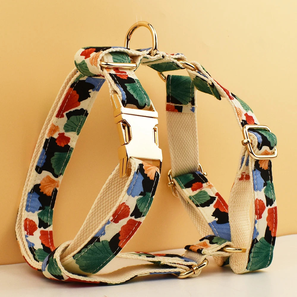 Floral-patterned dog harness with gold hardware on a beige background