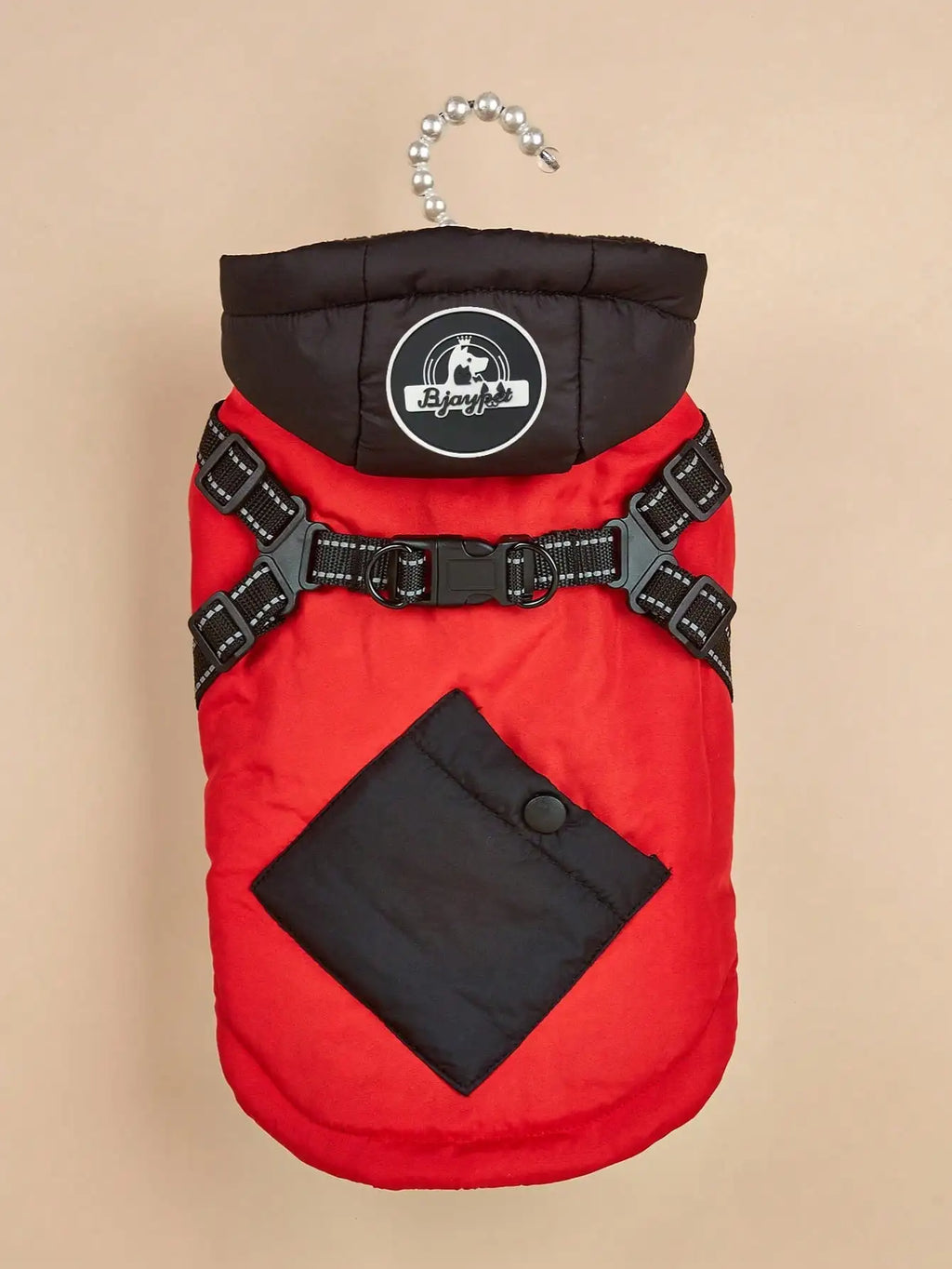 Red and black dog coat with harness on a beige background