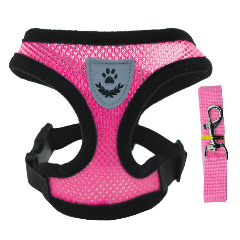 Pink dog harness with black trim and a matching pink leash on a white background