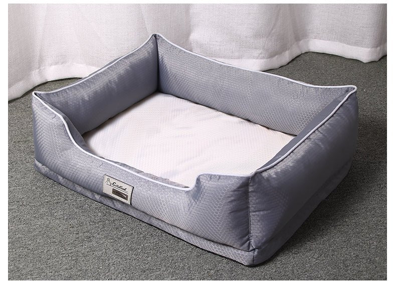 Gray pet bed with a white cushion on a gray floor.