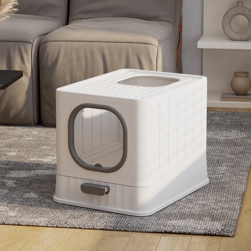 White pet litter box with gray door on a rug in a living room setting.