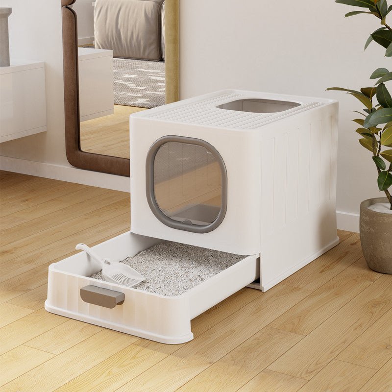 White pet litter box with transparent door on a wooden floor.