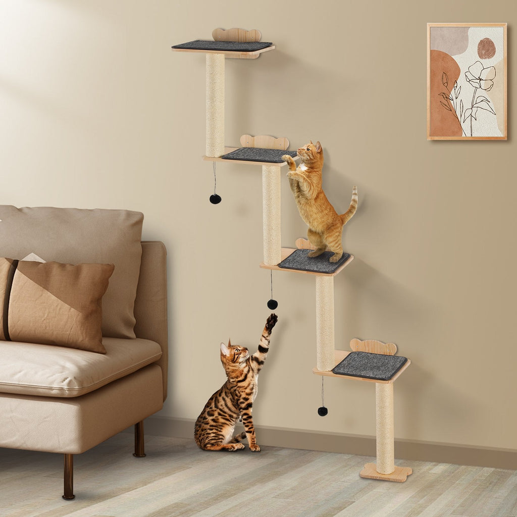Cat climbing a multi-level cat tree in a living room with a beige sofa and wall art.